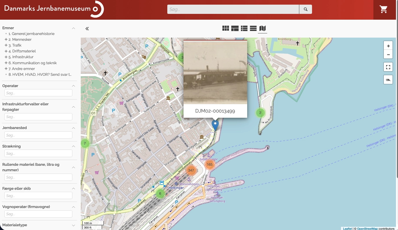 Kortvisning i Danmarks Jernbanemuseums portal. Til venstre søgefelter for emne, operatør, jernbanested, strækning, rullende materiel og færge; til højre et kort over Helsingør, hvor de fundne emner er samlet i nummererede klynger, og hvor en enkelt markør er foldet ud som et kort med et historisk foto af et færgeleje og nummeret DJM02-00013499.