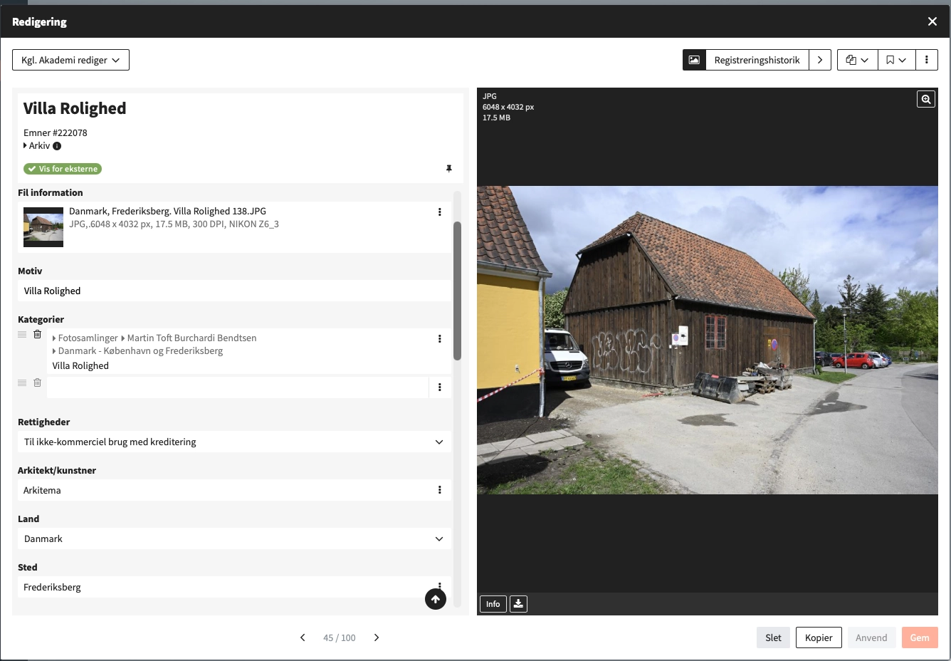 The full-screen editing window in Fylr. On the left, the fields on the record Villa Rolighed — file information, subject, categories, rights, architect, country and place — with a marker reading Vis for eksterne at the top; on the right, the photograph itself, a dark timber outbuilding beside a yellow villa, listed as a JPG of 6048 × 4032 px and 17.5 MB. A counter at the foot reads record 45 of 100.